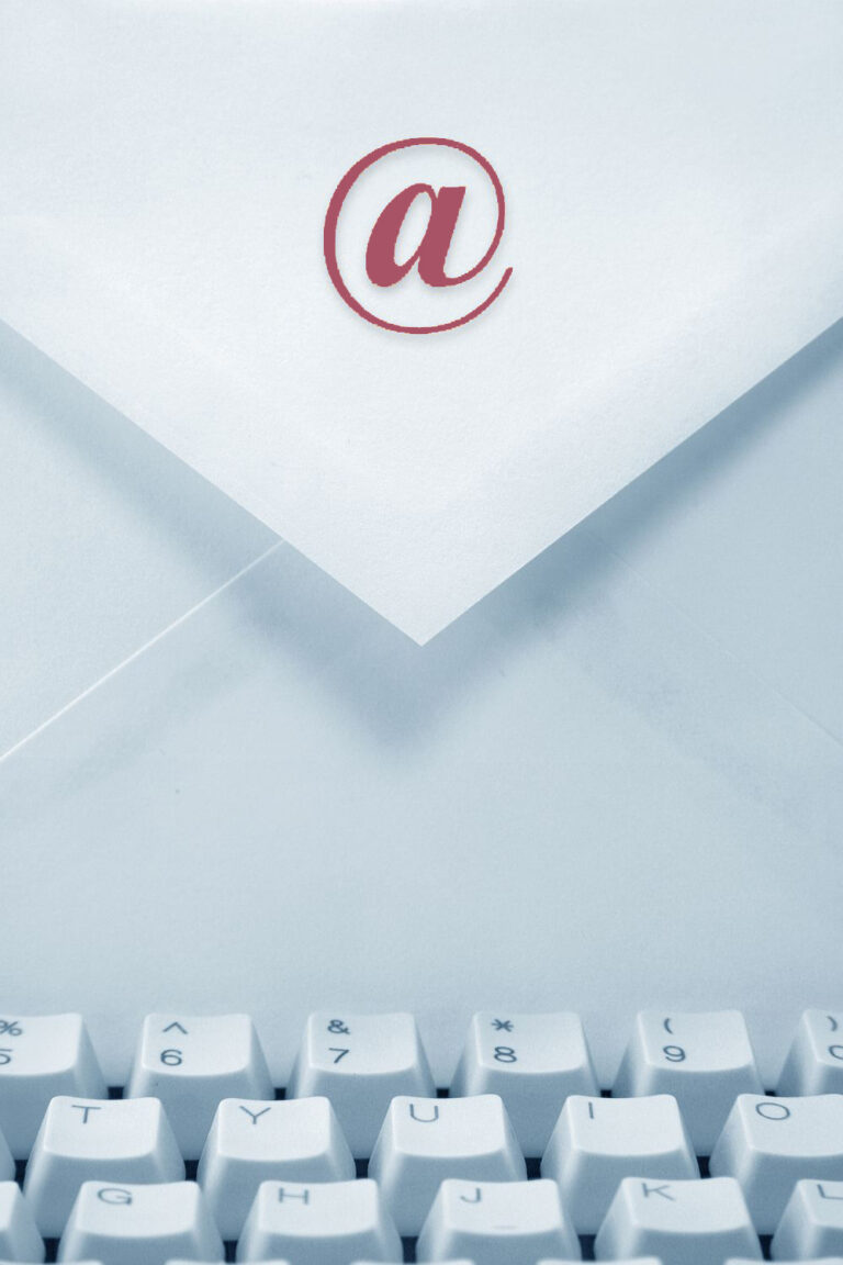 Letter envelope with @ symbol on the paper and a computer keyboard in the foreground.